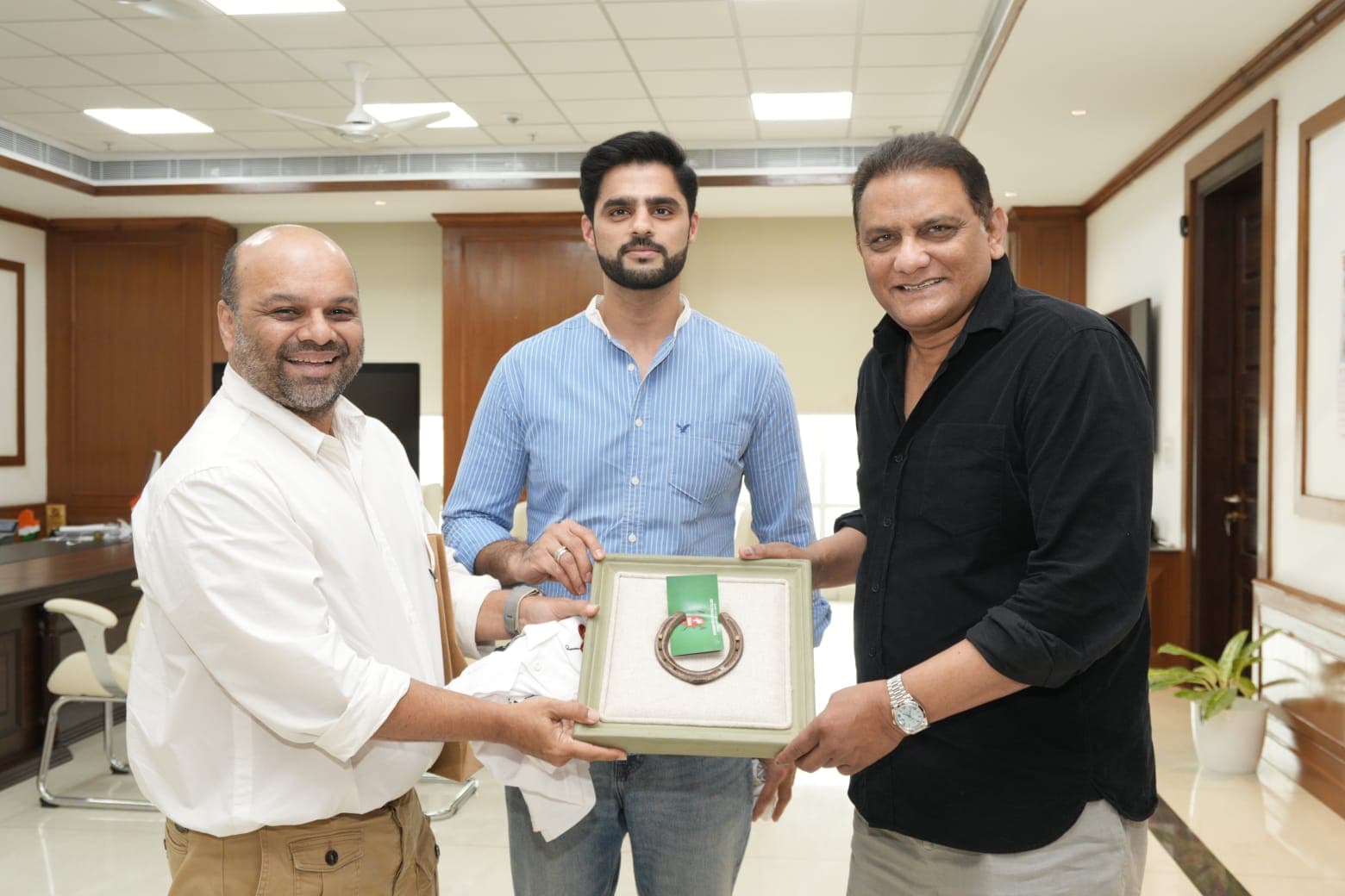 Mohammed Azharuddin with Chaitania Kumar and Arsalan Khan at the unveiling of the event invitation and framed horseshoe at Telangana Secretariat